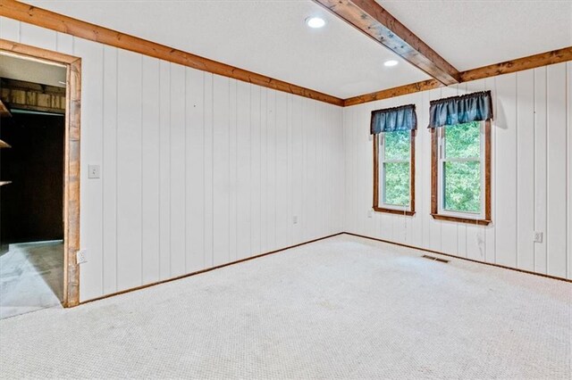 carpeted spare room with visible vents, beam ceiling, and recessed lighting