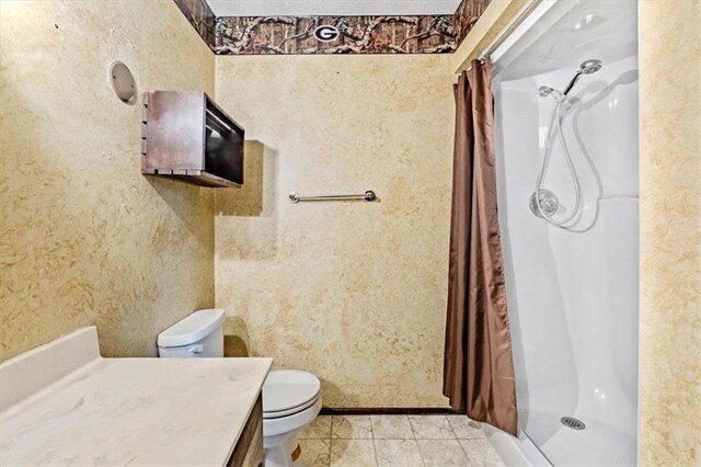 bathroom featuring a stall shower, vanity, toilet, and tile patterned floors