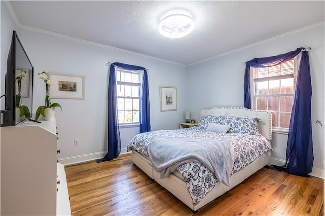 bedroom featuring wood finished floors, baseboards, and ornamental molding