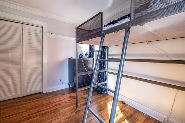 unfurnished bedroom with crown molding, wood finished floors, and baseboards