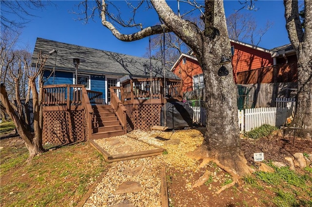 back of property featuring a deck, stairway, and fence