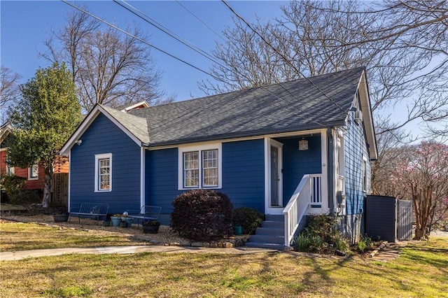 view of front of property with a front yard and roof with shingles