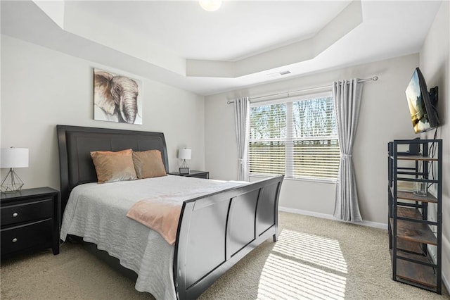 carpeted bedroom featuring a raised ceiling