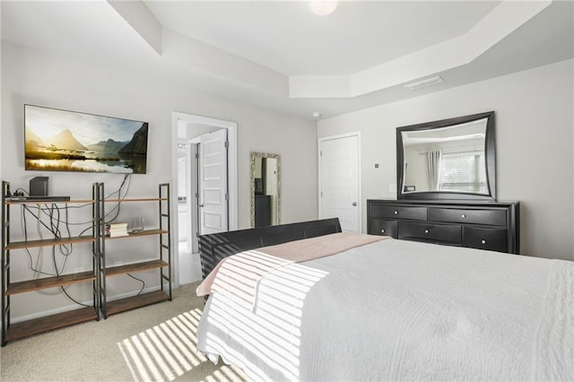 carpeted bedroom with a tray ceiling