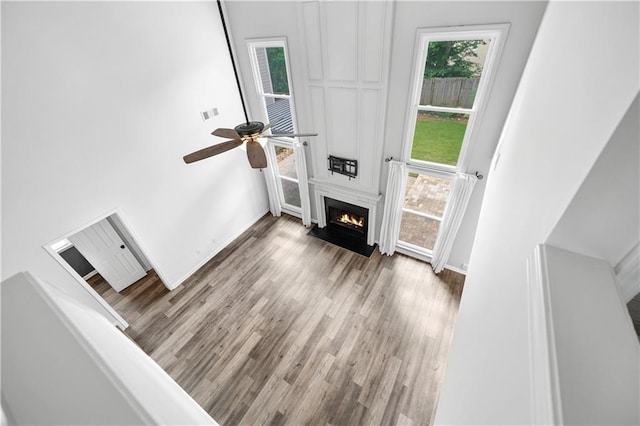 615 Rosedown Way, Alpharetta, GA 30022 - unfurnished living room featuring a ceiling fan, wood finished floors, a fireplace, and a high ceiling