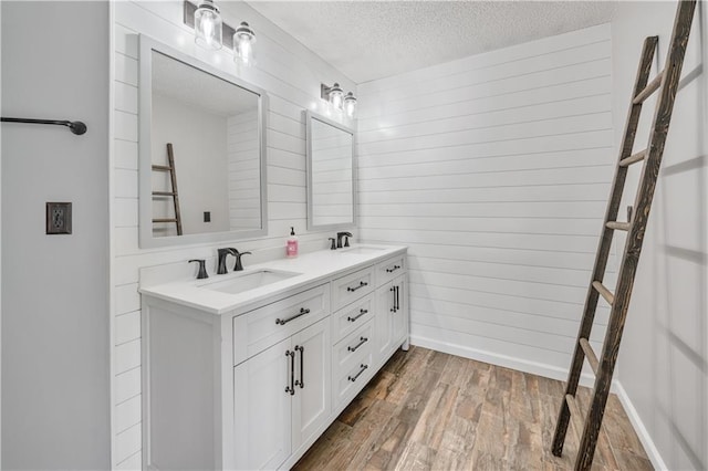 615 Rosedown Way, Alpharetta, GA 30022 - bathroom with double vanity, a textured ceiling, wood finished floors, and wooden walls