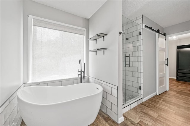 615 Rosedown Way, Alpharetta, GA 30022 - bathroom with a stall shower, a soaking tub, wood finished floors, plenty of natural light, and a textured ceiling