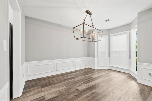 615 Rosedown Way, Alpharetta, GA 30022 - unfurnished dining area with a chandelier, a wainscoted wall, wood finished floors, and a decorative wall