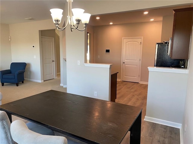 dining room with light hardwood / wood-style flooring and an inviting chandelier