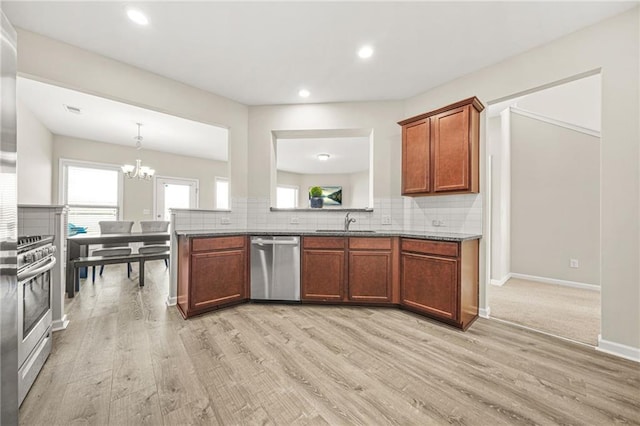 kitchen with brown cabinets, appliances with stainless steel finishes, decorative backsplash, and a sink