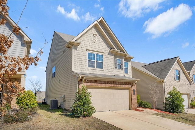 craftsman house with an attached garage, central AC unit, concrete driveway, and brick siding