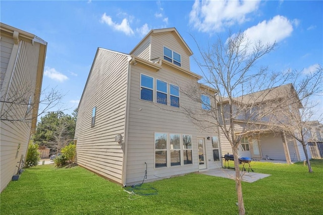 rear view of property featuring a lawn and a patio area