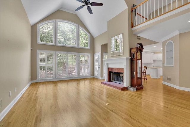 unfurnished living room featuring visible vents, light wood-style floors, ceiling fan, and high vaulted ceiling
