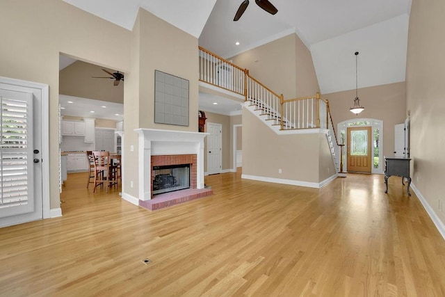 unfurnished living room with baseboards, a ceiling fan, light wood-style flooring, and high vaulted ceiling