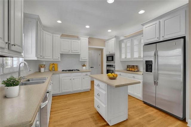 kitchen with a sink, appliances with stainless steel finishes, tasteful backsplash, and light countertops