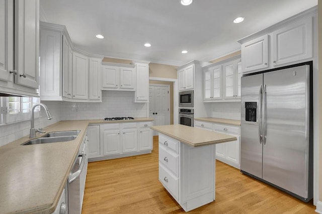 kitchen featuring light countertops, a sink, appliances with stainless steel finishes, and tasteful backsplash