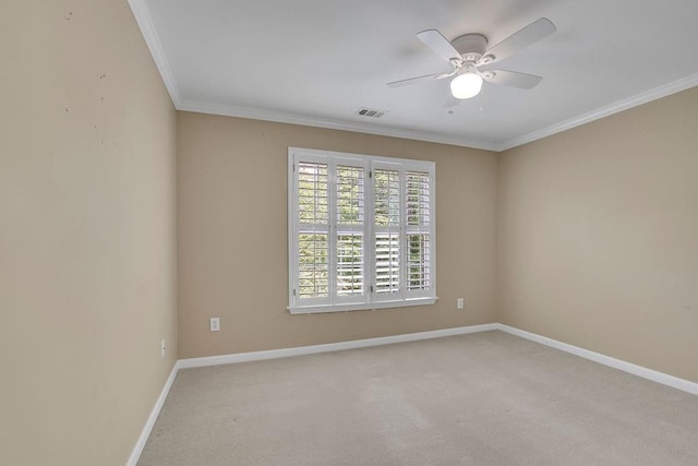 empty room featuring crown molding, carpet flooring, a ceiling fan, baseboards, and visible vents