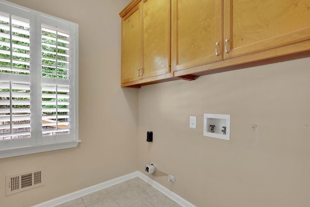 washroom with visible vents, baseboards, cabinet space, washer hookup, and light tile patterned floors