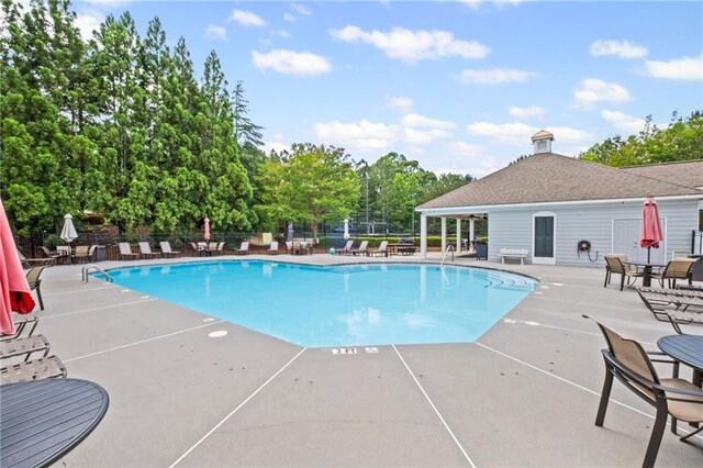 121 Bradshaw Park Dr, Woodstock, GA 30188 - community pool with a patio, view of wooded area, and grilling area