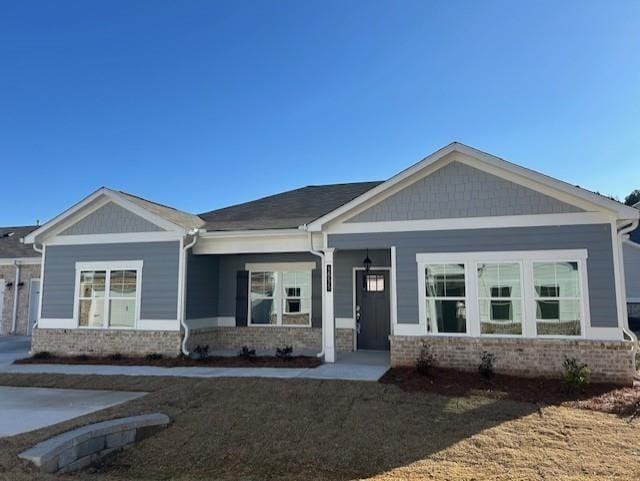 craftsman-style home with covered porch and a front lawn