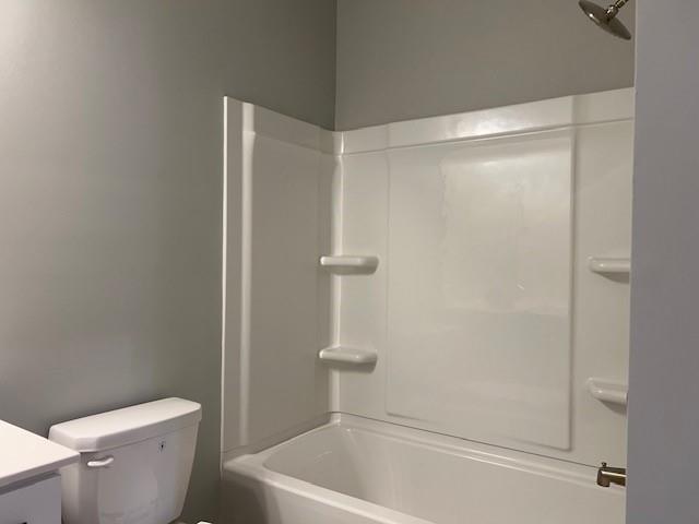 full bathroom with washtub / shower combination, vanity, and toilet