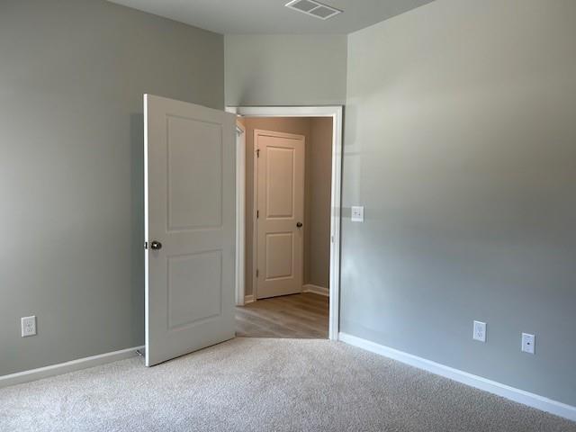 unfurnished room featuring light colored carpet