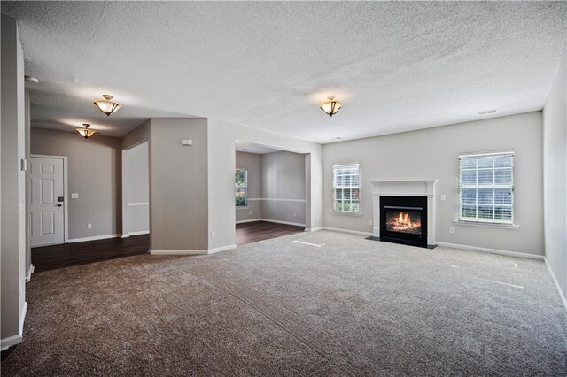 3223 Tallon Ln SW, Atlanta, GA 30311 - unfurnished living room featuring carpet, a textured ceiling, baseboards, and a fireplace with flush hearth