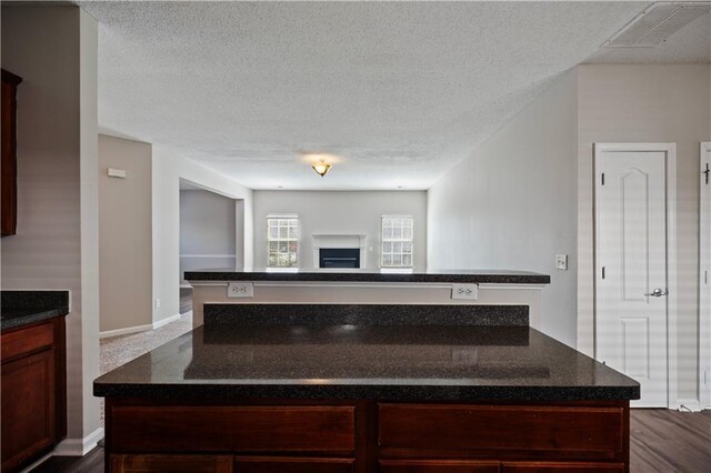 3223 Tallon Ln SW, Atlanta, GA 30311 - kitchen featuring a kitchen island, a textured ceiling, open floor plan, dark stone counters, and dark wood-style floors