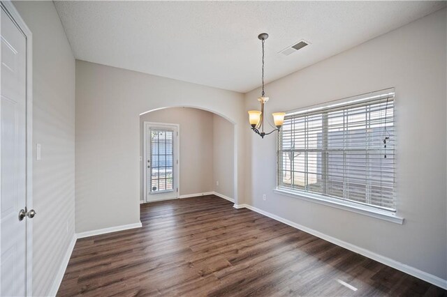 3223 Tallon Ln SW, Atlanta, GA 30311 - unfurnished room with arched walkways, a chandelier, dark wood-type flooring, and baseboards