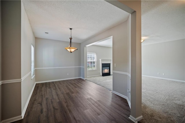 3223 Tallon Ln SW, Atlanta, GA 30311 - unfurnished dining area featuring a textured ceiling, wood finished floors, baseboards, and a glass covered fireplace