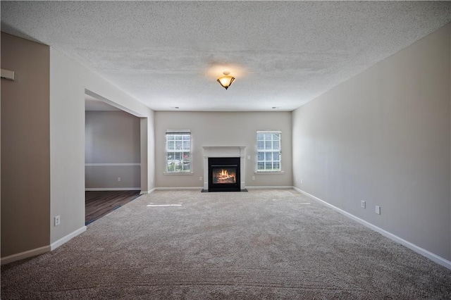 3223 Tallon Ln SW, Atlanta, GA 30311 - unfurnished living room with carpet floors, baseboards, a fireplace with flush hearth, and a textured ceiling