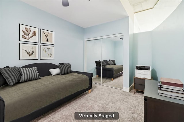 bedroom featuring light colored carpet, a closet, and ceiling fan