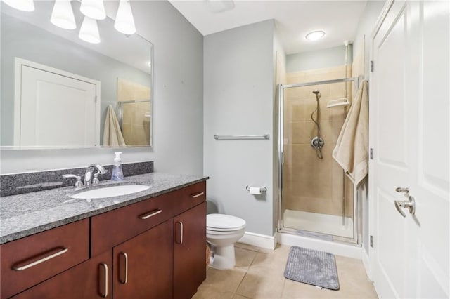 bathroom featuring vanity, tile patterned flooring, toilet, and walk in shower