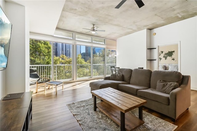 living room featuring ceiling fan, a healthy amount of sunlight, and wood-type flooring