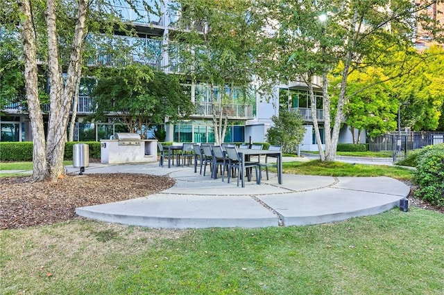 view of community with an outdoor kitchen, a yard, and a patio area