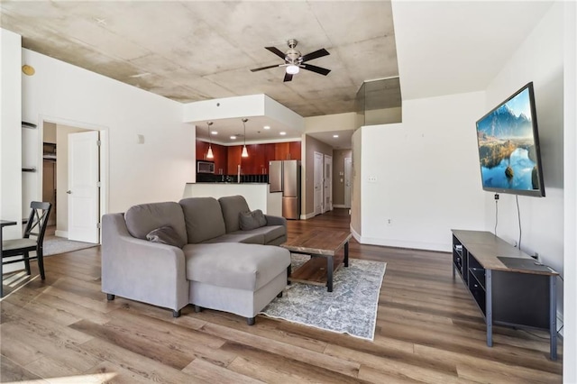 living room featuring ceiling fan and dark hardwood / wood-style floors