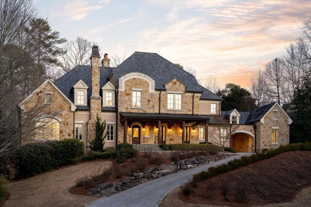 french provincial home with covered porch