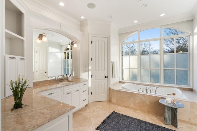 bathroom featuring vanity, tiled tub, ornamental molding, and tile patterned floors