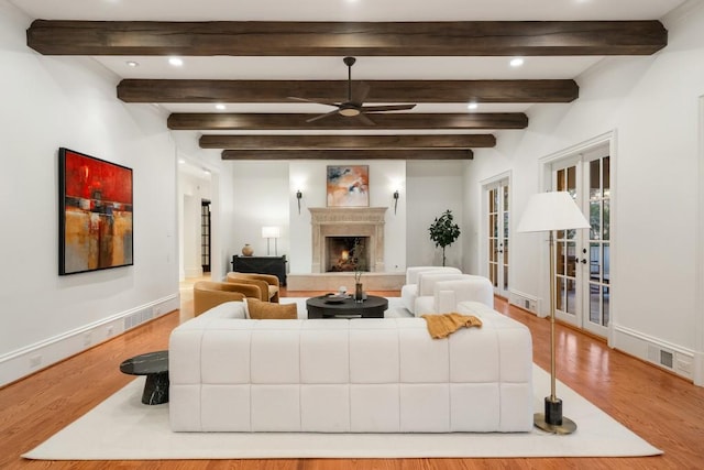 living room featuring french doors, ceiling fan, light hardwood / wood-style flooring, and beamed ceiling