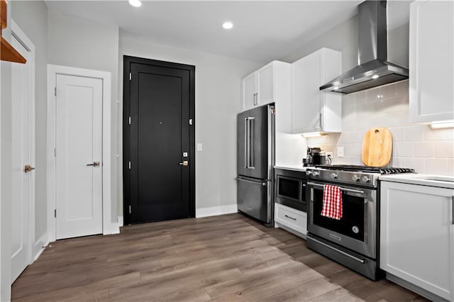 kitchen featuring high quality appliances, white cabinetry, dark hardwood / wood-style flooring, decorative backsplash, and wall chimney exhaust hood