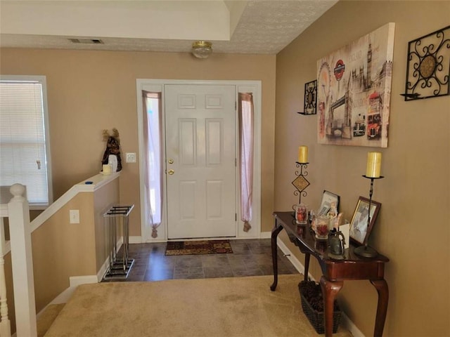 entrance foyer featuring dark tile patterned flooring