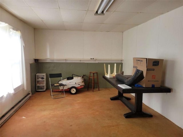 interior space featuring a healthy amount of sunlight, concrete floors, and a baseboard heating unit