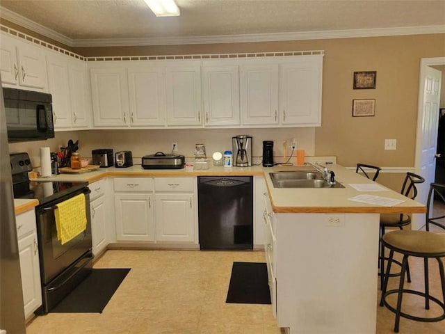 kitchen featuring white cabinetry, sink, crown molding, a breakfast bar, and black appliances