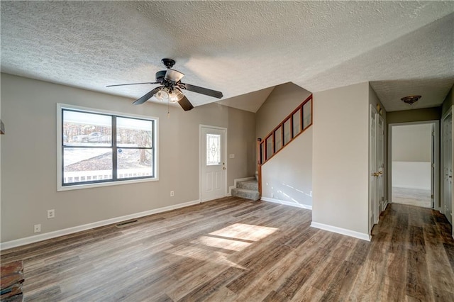 unfurnished living room featuring ceiling fan, hardwood / wood-style floors, and a textured ceiling