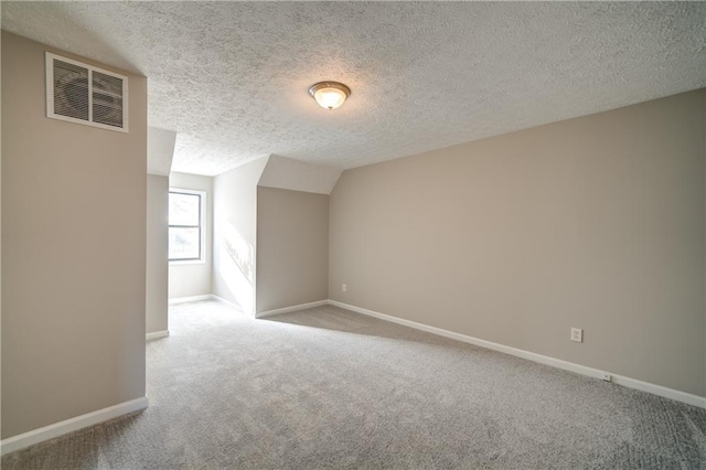 bonus room with light colored carpet, a textured ceiling, and lofted ceiling