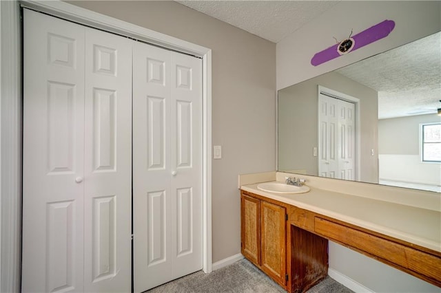 bathroom with a textured ceiling, ceiling fan, and vanity