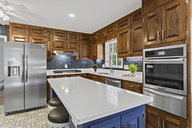 kitchen with tasteful backsplash, appliances with stainless steel finishes, sink, and a kitchen island