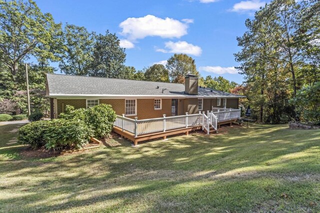 back of house featuring a yard and a wooden deck