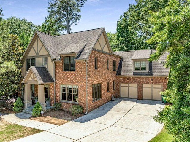 504 S Westminster Way NE, Atlanta, GA 30307 - english style home with concrete driveway, roof with shingles, an attached garage, and brick siding
