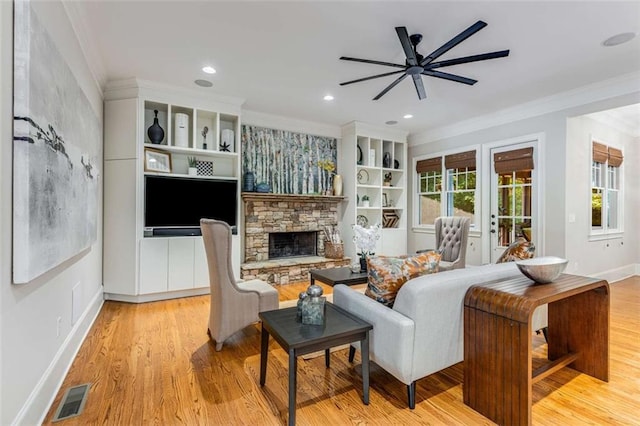504 S Westminster Way NE, Atlanta, GA 30307 - living room featuring ceiling fan, ornamental molding, a stone fireplace, light wood-type flooring, and baseboards
